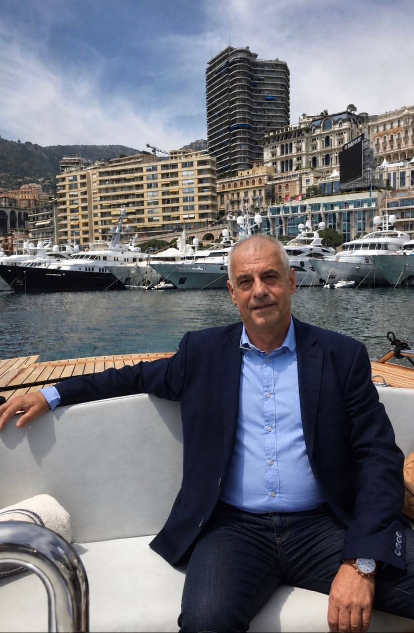 Vassilis Koukoulas seated aboard a yacht in a marina